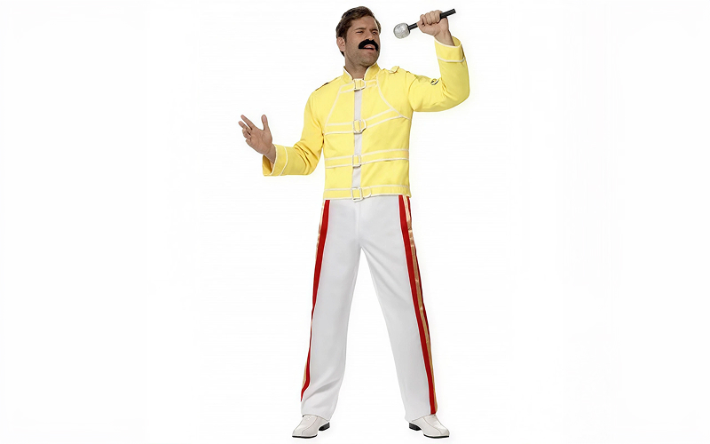 Man wearing Freddie Mercury yellow jacket costume holding microphone.